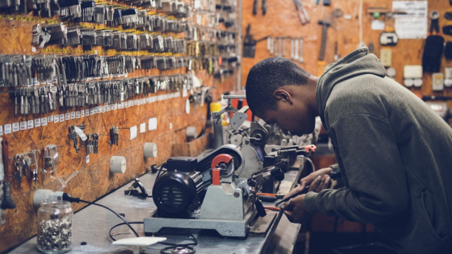 Man working, holding metal near power supply. (Photo by Caio from Pexels)